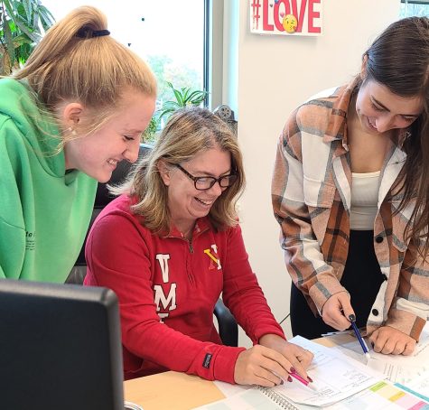 Math teacher Mrs. Wick instructs a pair of students before the start of class. Photo taken by Deshaun Jefferson.